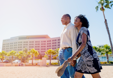 Photo of a couple walking on a beach near a condo building in Florida