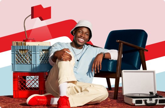 Photo of a young man sitting in his living room with a chair, record player, and a lamp with the National Bank logo