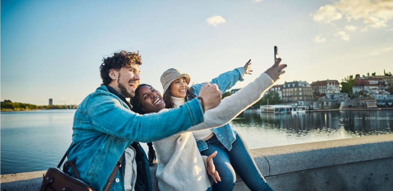 Photo of a group of people taking a picture near a body of water 