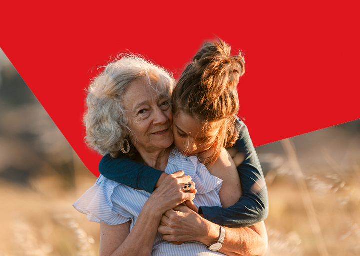 Photo of a granddaughter hugging her grandmother representing National Bank’s wealth management and succession planning services 